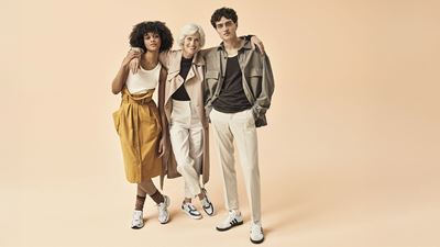 Tre persone alla moda su uno sfondo di rosa pesca