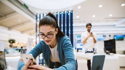 Una potenziale acquirente in un negozio utilizza uno smartphone